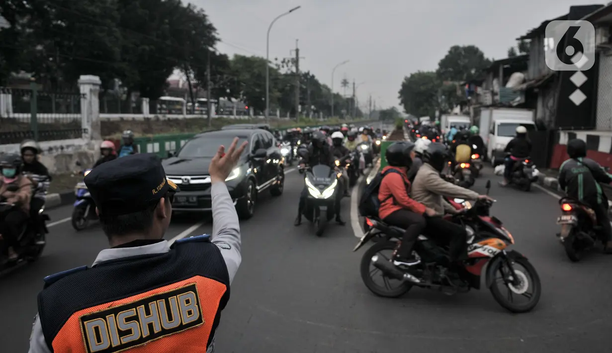 Petugas Dishub mengatur lalu lintas saat sebagian pengendara sepeda motor melawan arah ke jalan alternatif untuk menghindari kemacetan di Underpass Pasar Minggu, Jakarta, Kamis (12/3/2020). Kemacetan di Underpass Pasar Minggu semakin parah saat jam pulang kerja. (merdeka.com/Iqbal Nugroho)