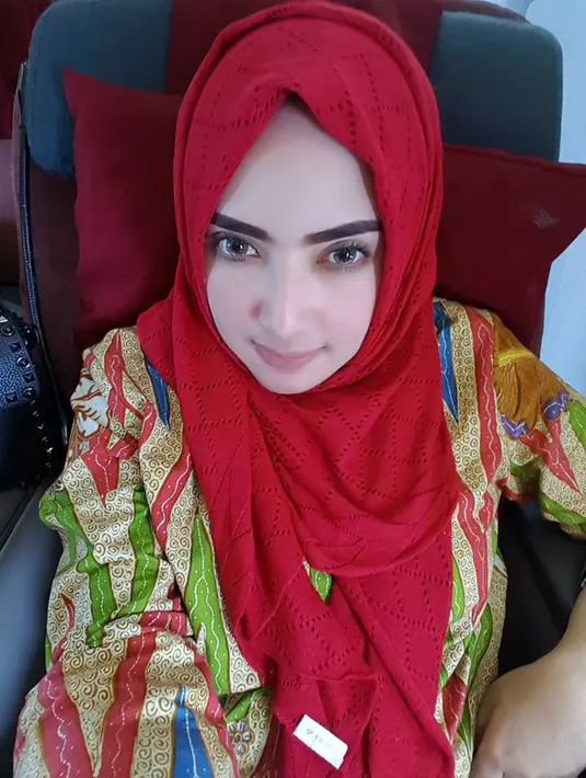 Tak lagi berbusana hitam, namun Yulia kali ini memilih mengenakan baju colorful dengan kerudung merahnya. Dan pastinya penampilannya semakin merona dan mencuri perhatian publik. (Doc.Facebook)