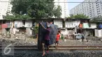 Warga membawa kasur saat alat berat merobohkan bangunan rumah mereka di kawasam Rawajati, Jakarta, Kamis (1/9). Penertiban tersebut menyebabkan warga terpaksa menyelamatkan barang berharga mereka ke tepi rel kereta api. (Liputan6.com/Immanuel Antonius)