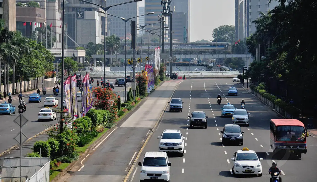 Kendaraan melewati jalan protokol di kawasan Bundaran HI menuju Jalan Sudirman, Jakarta, Senin (4/8/14). (Liputan6.com/Faizal Fanani)
