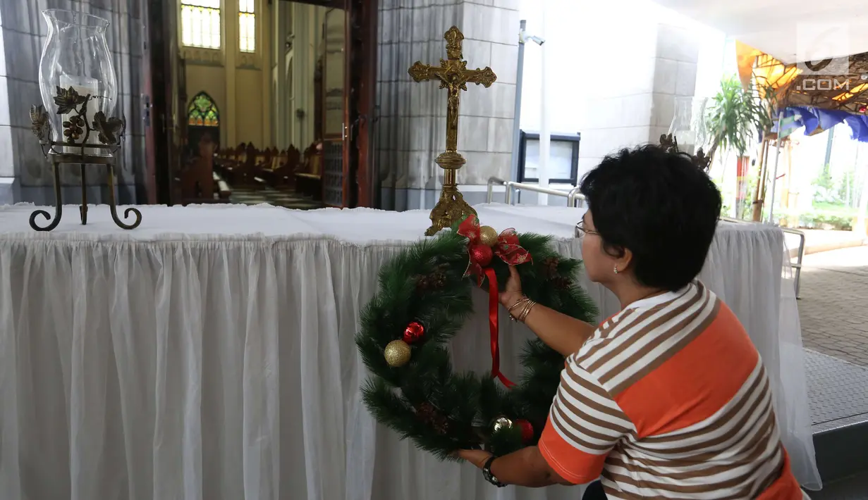 Umat kristen dan pengurus menata dekorasi di Gereja Katedral, Jakarta, Sabtu (23/12). Jelang perayaan natal Gereja Katedral mulai bebenah dan dipercantik untuk keperluan ibadah natal. (Liputan6.com/Angga Yuniar)