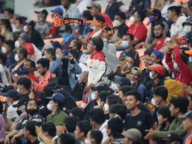 Seorang penonton menerikkan dukungan saat laga International Youth Championship 2021 antara Indonesia All Stars U-20 melawan Barcelona U-18 di Jakarta International Stadium, Jakarta, Rabu (13/04/2022). (Bola.com/Bagaskara Lazuardi)