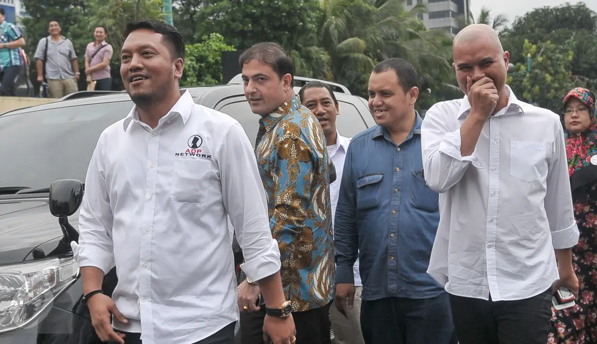 Ahmad Dhani bersama kuasa hukumnya saat tiba di Polda Metro Jaya, Jakarta, Rabu (9/11). Ahmad Dhani melaporkan pihak yang menuduhnya menghina Presiden Joko Widodo. (Liputan6.com/Yoppy Renato)