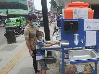 Warga menggunakan fasilitas tempat cuci tangan atau wastafel portabel di Pasar Bogor, Jalan Suryakencana, Kota Bogor, Sabtu (29/3/2020). Pemerintah Kota Bogor menerima bantuan berupa tempat cuci tangan portable dari Ikatan Alumni Teknik dan Alumni Ekonomi UI. (merdeka.com/Arie Basuki)