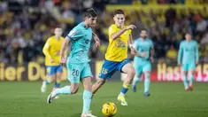 Pemain Barcelona, Sergi Roberto, berusaha melewati pemain Las Palmas, Mika Marmol, pada laga La Liga 2023/2024 jornada 19 di Estadio de Gran Canaria, Jumat (5/1/2024). Barca sejatinya sempat tertinggal lebih dahulu akibat gol Munir El Haddadi. Pasukan Xavi bangkit dengan mencetak gol lewat aksi Ferran Torres di awal babak kedua dan eksekusi penalti Ilkay Gundogan di masa injury time. (AFP/Desiree Martin)