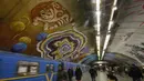Penumpang melewati kereta di bawah mural yang menghiasi dinding stasiun metro bawah tanah kota di Kyiv, Ukraina, Rabu, (29/1/2020). (AP Photo / Efrem Lukatsky)