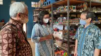 Pemilik UMKM binaan Yayasan Dharma Bhakti Astra (YDBA) ABC Woodentoys, Rita Indriana (tengah) menunjukkan salah satu produknya kepada Ketua Pengurus YDBA, Sigit P. Kumala (kanan) dan Advisor YDBA, Tonny Sumartono (kiri) dalam kegiatan #YukExplore UMKM Indonesia di Yogyakarta. (Liputan6.com)