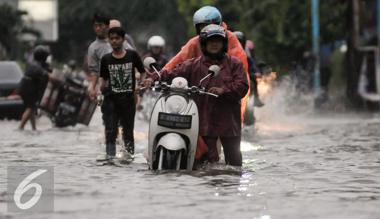 Pengendara mendorong motornya yang mogok akibat menerebos banjir di Jalan Kemang Raya, Jakarta, Jumat (11/11). Hujan deras yang mengguyur wilayah Jakarta menyebabkan banjir di kawasan Jalan Kemang Raya. (Liputan6.com/Yoppy Renato)
