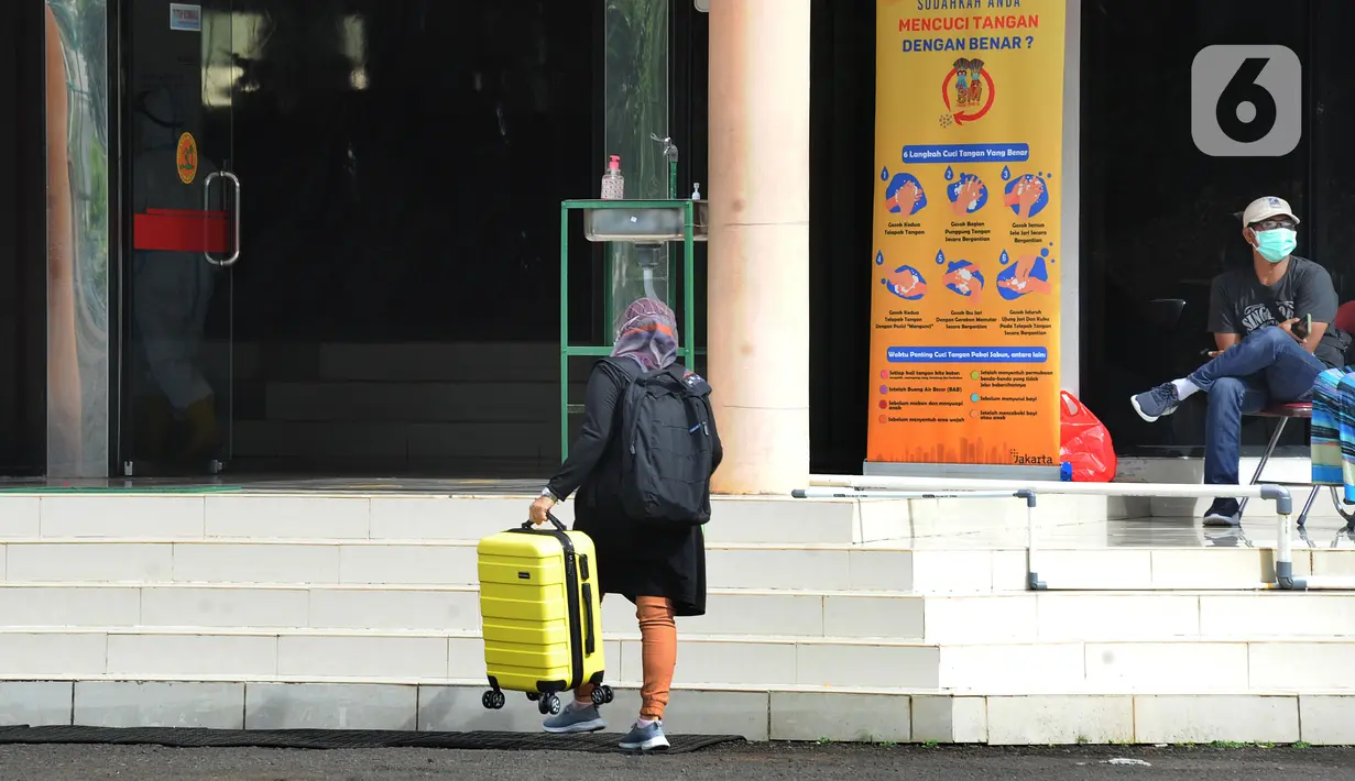 Pasien OTG Covid-19 membawa barang miliknya untuk dirawat di Graha Wisata Ragunan, Jakarta, (21/12/2020). Bagi pasien Covid-19 yang menolak untuk melakukan isolasi di tempat yang sudah disediakan, maka petugas dan aparat penegak hukum akan melakukan penjemputan paksa. (merdeka.com/Arie Basuki)