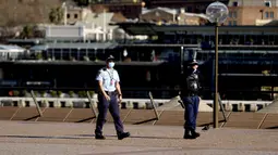 Polisi berpatroli di sekitar Gedung Opera, Sydney, Australia, Selasa (13/7/2021). Lima juta penduduk Sydney akan berada dalam lockdown COVID-19 untuk dua minggu lagi. (Brendon THORNE/AFP)