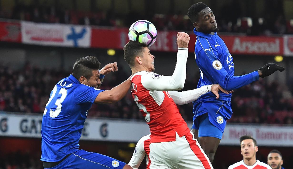 Bek Arsenal, Gabriel, membuang bola dari jangkauan pemain Leicester pada laga Premier League di Stadion Emirates, London, Rabu (26/4/2017). Arsenal menang 1-0 atas Leicester. (AFP/Glyn Kirk)