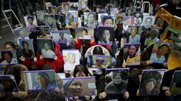 Sejumlah orang memegangi foto - foto wanita mantan perbudakan seks Militer Jepang di Seoul, Korea Selatan, (30/12). Kabarnya Jepang menawarkan kompensasi sekitar Rp112,8 miliar untuk kerabat wanita korban budak seks. ( REUTERS/Kim Hong - Ji)