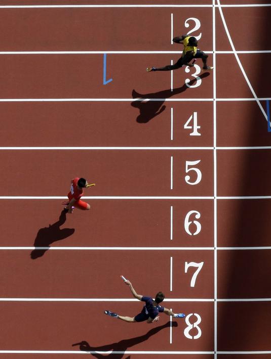 Pelari Jamaika, Usain Bolt menjadi yang terdepan saat memasuki garis finish pada nomor lari estafet 4x100m putra di World Athletics Championships, London (12/8/2017). (AP/David J. Phillip)