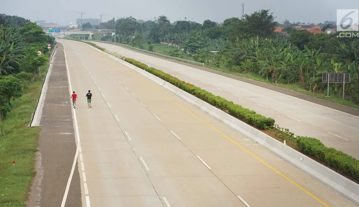 Warga berolahraga lari di Jalan Tol Cijago Seksi II ruas Bogor-Kukusan, Depok, Jawa Barat, Senin (17/6/2019). Setelah sempat diuji coba selama dua pekan, ruas tol yang nantinya menghubungkan jalur Jagorawi-Cinere tersebut kembali ditutup untuk umum. (Liputan6.com/Immanuel Antonius)