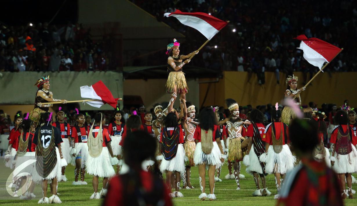 Penari mengibarkan bendera Merah Putih saat pembukaan Torabika Soccer Championship presented by IM3 Ooredoo di Stadion Mandala Jayapura, Papua, Jumat (29/4/2016). Laga perdanamempertemukan Persipura vs Persija. (Liputan6.com/Helmi Fithriansyah)