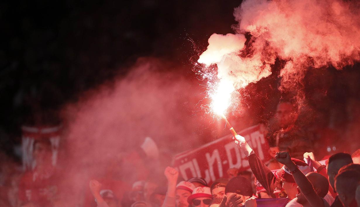 Suporter FC Cologne menyalakan flare saat tandang ke kandang Arsenal pada laga Liga Europa di Stadion Emirates, London, Rabu (14/9/2017). Arsenal menang 3-1 atas Cologne. (AP/Kirsty Wigglesworth)