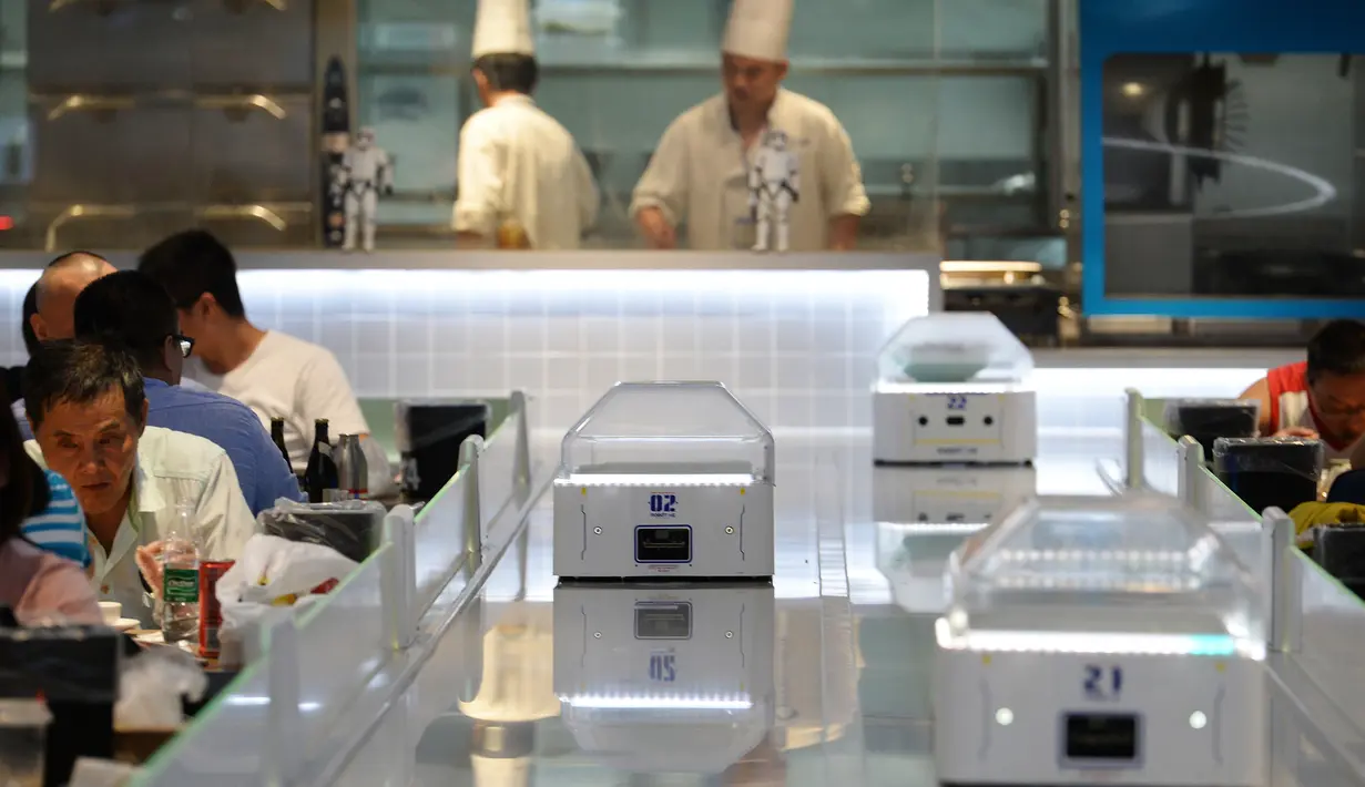 Robot pelayan untuk menerima pesanan dan mengantarkan makanan di restoran Robot.He, Shanghai, 30 Juli 2018. Robot-robot ini dipandu software yang menggunakan sistem kode QR untuk mengetahui posisi pelanggan pemesan, pesanan dan pembayaran. (AFP)