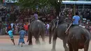 Sejumlah warga menyaksikan pertandingan gajah untuk menandai Tahun Baru Sinhala dan Tamil di Homagama dekat Colombo (21/4). Sejumlah perlombaan diadakan saat tahun baru umat Hindu, Sinhala dan Tamil yang jatuh 14 April. (AFP Photo/Lakruwan Wannirachchi)