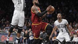 Bintang Cleveland Cavaliers, LeBron James (23)  menlakukan layup melewati hadangan para pemain Brooklyn Nets pada laga NBA basketball game di Barclays Center, (6/1/2017). Cavs menang 116-108. (AP/Frank Franklin II)