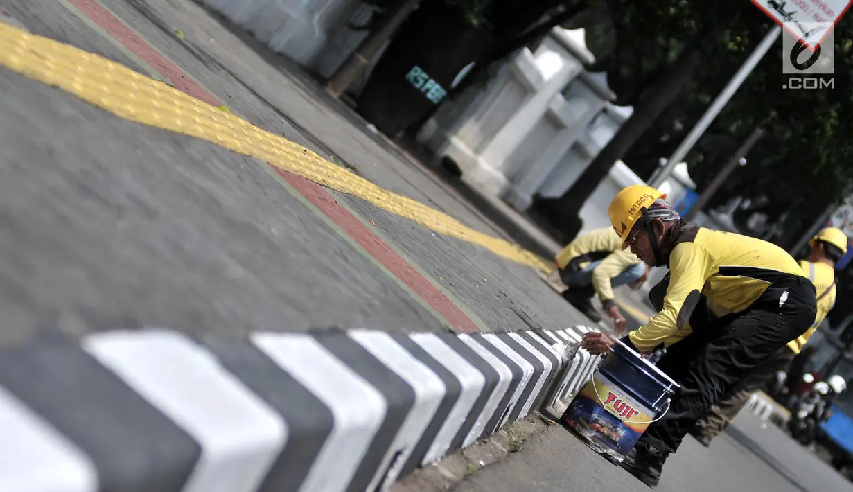 Petugas Suku Dinas Bina Marga Jakarta Timur saat menyelesaikan pengecatan trotoar di Jalan Persahabatan Raya, Jakarta, Rabu (27/3). Kegiatan pengecatan ini rutin dilakukan guna merawat sekaligus mempercantik jalur pedestrian tersebut. (merdeka.com/Iqbal S. Nugroho)