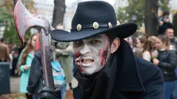 Seorang pria berpose dengan dandanan menyerupai zombie ketika berpartisipasi dalam 'Zombie Walk' di pusat Kota Kiev, Ukraina, 26 Oktober 2019. Menjelang perayaan Halloween pada 31 Oktober mendatang, warga di beberapa belahan dunia sudah mulai melakukan acara bertema horor. (AP/Efrem Lukatsky)