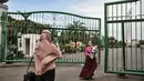 Warga berfoto di depan gerbang masuk Monumen Nasional (Monas), Jakarta, Minggu (15/11/2020). Meski masih ditutup untuk umum sejak awal pandemi Covid-19, kawasan Monas tetap ramai dikunjungi warga untuk sekadar mengisi akhir pekan. (merdeka.com/Iqbal S Nugroho)