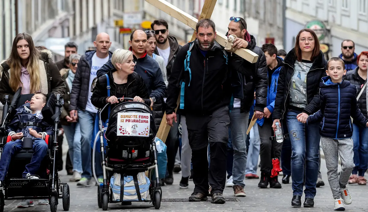 Seorang pria asal Kroasia, Sasa Pavlic tiba di ibu kota Zagreb sambil membawa salib, Kamis (5/4). Sasa Pavlic melakukan aksi protes dengan berjalan kaki sejauh 200 kilometer sambil membawa salib kayu seberat 20 kilogram di pundaknya. (AFP PHOTO/STR)