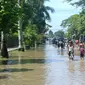 Anak sekolah melintasi genangan banjir di Sidareja, Cilacap, Jawa Tengah. (Foto: Liputan6.com/Muhamad Ridlo)