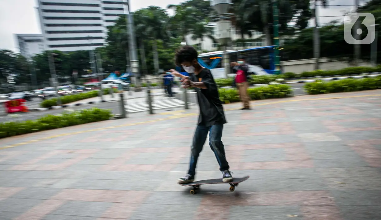 Aksi warga saat bermain skateboard di trotoar Jalan Sudirman-Thamrin, Jakarta, Jumat (5/3/2021). Gubernur DKI Jakarta Anies Baswedan mengizinkan trotoar untuk digunakan sebagai tempat bermain skateboard dengan beberapa kesepakatan. (Liputan6.com/Faizal Fanani)