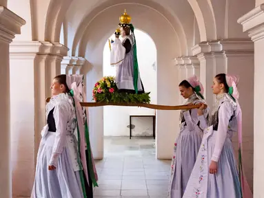 Sejumlah remaja mengenakan pakaian tradisional Sorbs memikul patung Bunda Maria saat mengikuti prosesi Whit Monday di gereja di Rosenthal, Jerman (21/5). Prosesi tradisional ini di gelar di dekat perbatasan Jerman-Polandia. (AP Photo / Jens Meyer)