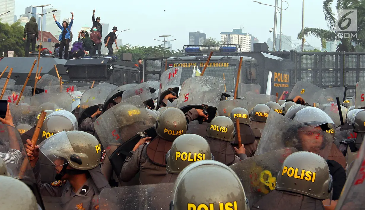 Polisi menghalau mahasiswa dalam demonstrasi menolak pengesahan RUU KUHP dan revisi UU KPK di depan Gedung DPR, Jakarta, Selasa (24/9/2019). Polisi menghalau mahasiswa yang berusaha masuk ke area Gedung DPR. (Liputan6.com/JohanTallo)