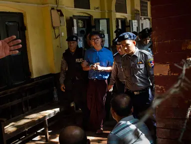 Wartawan Reuters Wa Lone (tengah) dikawal oleh polisi setelah menjalani sidang di Yangon (10/1). Polisi Myanmar resmi mengajukan tuntutan terhadap dua wartawan Reuters yang dituduh membocorkan rahasia negara. (AFP Photo/Ye Aung Thu)