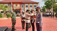 Kapolres Paser, AKBP Kade Budiyarta menyematkan pita kepada personel tanda dimulainya Operasi Patuh Mahakam 2022, halaman Mapolres Paser, Senin (13/6/2022). (Liputan6.com/istimewa)