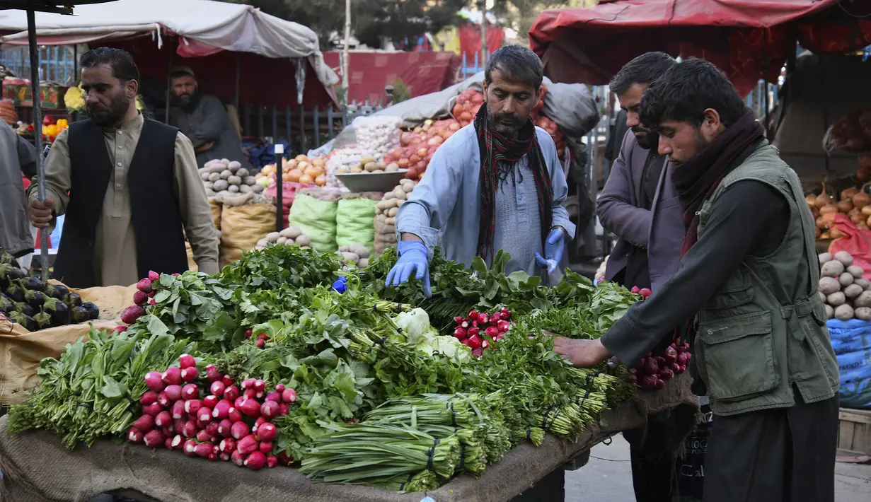 Dalam gambar yang diambil pada 5 April 2022, orang-orang membeli sayuran di pasar selama bulan suci Ramadhan di Kabul, Afghanistan. (Sahel ARMAN / AFP)