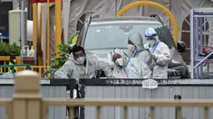 Personel keamanan yang mengenakan alat pelindung diri (APD) berjaga di pintu masuk ke area perumahan yang dikunci karena wabah virus corona COVID-19 baru-baru ini di Beijing, China, Selasa (10/5/2022). Jutaan orang di Beijing tinggal di rumah pada 9 Mei ketika Ibu Kota China tersebut mencoba untuk menangkis wabah COVID-19 dengan pembatasan pergerakan. (Noel Celis/AFP)