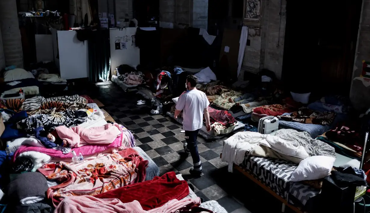 Seorang perawat berjalan di Gereja Saint-Jean-Baptiste-au-Beguinage yang diduduki oleh para migran tidak berdokumen di Brussel, Beliga, Rabu (2/6/2021). Para migran menyerukan lebih banyak inisiatif untuk memungkinkan mereka bekerja.
(Kenzo TRIBOUILLARD/AFP)