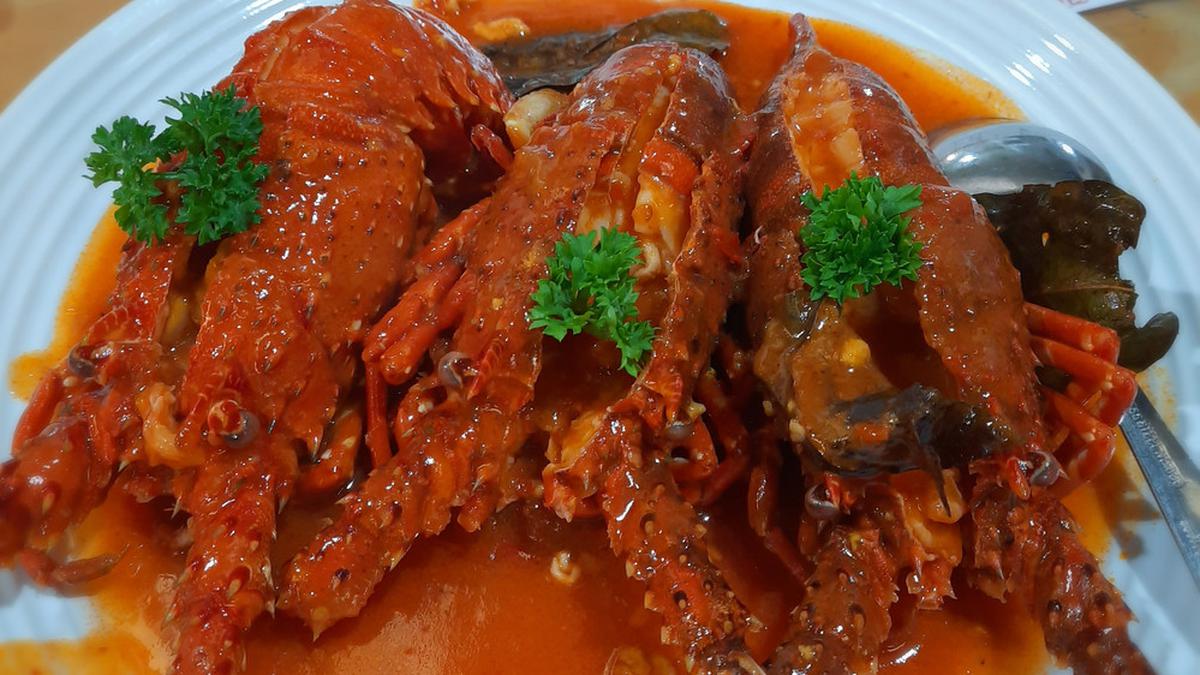 Lobster kuah pedas dengan warna merah menyala, disajikan dengan kuah gurih berempah yang menggugah selera
