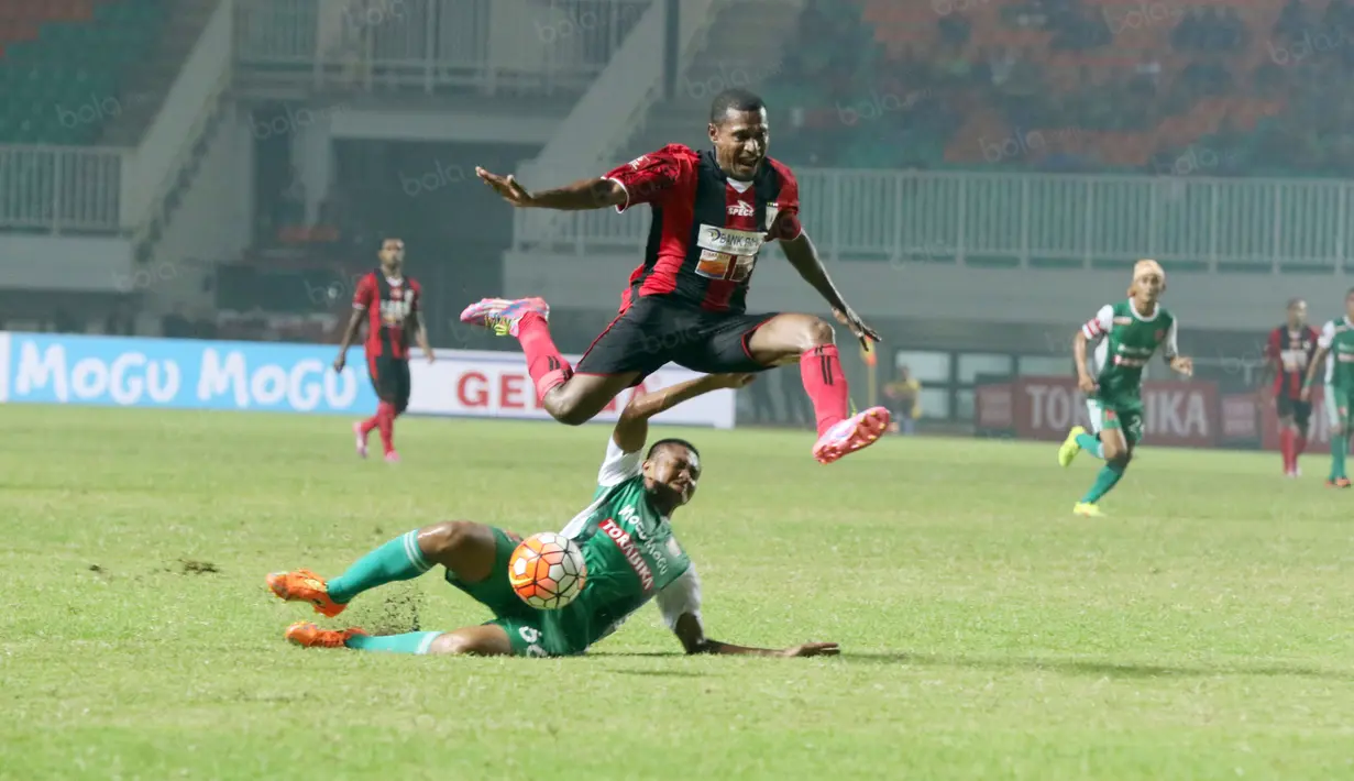 Pemain Persipura Jayapura, Tinus Pae melompat menghindari sapuan pemain PS TNI, Ganjar pada laga Torabika SC 2016 di Stadion Pakansari, Bogor, Minggu (19/6/2016). (Bola.com/Nicklas Hanoatubun)