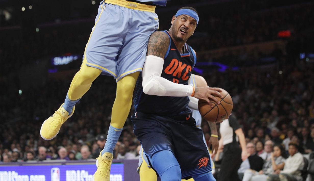 Pemain Oklahoma City Thunder, Carmelo Anthony (kanan) mencoba melewati adangan pemain Angeles Lakers pada laga NBA basketball game di Staples Center, Los Angeles, (3/1/2018). Lakers kalah 96-133. (AP/Jae C. Hong)