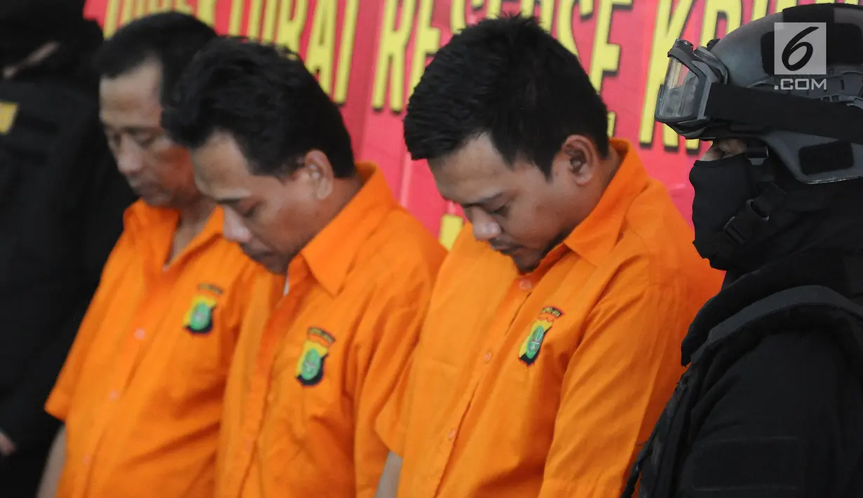 Tersangka dihadirkan saat rilis pengungkapan kasus pemalsuan mata uang asing di Polda Metro Jaya, Jakarta, Senin (8/4). Subdit 3 Resmob Dit Reskrimum Polda Metro Jaya berhasil mengamankan tiga orang tersangka beserta barang bukti di Sawangan, Depok, Jawa Barat. (Liputan6.com/Herman Zakharia)