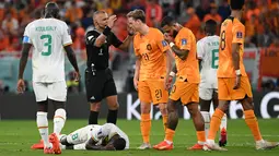 Gelandang Senegal #08 Cheikhou Kouyate terbaring di lapangan setelah mengalami cedera pada pertandingan kedua Grup A Piala Dunia 2022 di Stadion Al-Thumama di Doha, Senin (21/11/2022). Gelandang Timnas Belanda, Frenkie de Jong, secara tidak sengaja menyentuh bagan vital Cheikhou Kouyate saat berebut bola di udara. (OZAN KOSE / AFP)