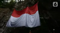 Jaringan Masyarakat Peduli Karst Klapanunggal membentangkan bendera merah putih dalam rangka peringatan HUT ke-75 RI di Tebing Kutalingkung, Klapa Nunggal, Jawa Barat, Senin (17/8/2020). Sebanyak 80 orang mengikuti pengibaran bendera berukuran 15 meter x 10 meter tersebut. (merdeka.com/Imam Buhori)