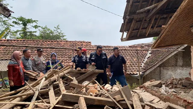 Pj. Bupati Garut Barnas Adjidin bersama petugas BPBD dan petugas gabungan lainnya saat meninjau salah satu rumah warga yang terdampak gempa magnitudo 4,2 kemarin. (Liputan6.com/Jayadi Supriadin)