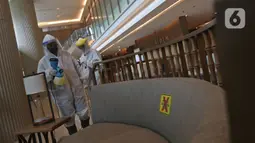 Petugas melakukan penyemprotan cairan disinfektan di lobi Kantor PLN Pusat, Jalan Trunojoyo, Blok M, Jakarta, Selasa (21/7/2020). PT PLN (Persero) menyemprotkan cairan disinfektan secara rutin dan berlaku protokol kesehatan selama pandemi COVID 19. (Liputan6.com/Herman Zakharia)