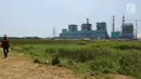 Pekerja melintas dekat pembangunan proyek pembangkit listrik tenaga uap (PLTU) Lontar unit 4 di Balaraja, Banten, Jumat (29/3/2019). Jika selesai, PLTU di atas tanah seluas 11 hektare persegi ini bisa memperkuat kapasitas listrik Jawa-Bali dan menghemat pengeluaran PLN (Liputan6.com/Herman Zakharia)