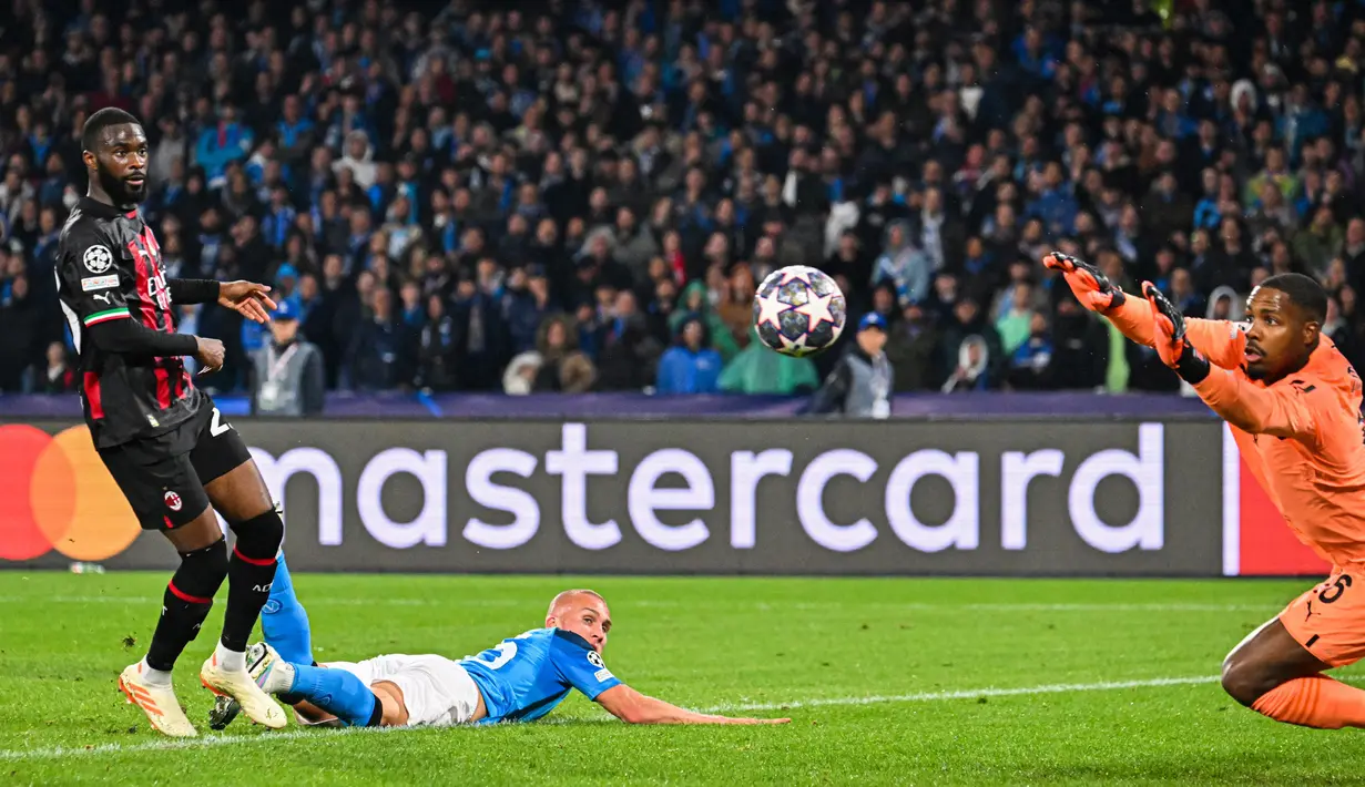 Kiper AC Milan, Mike Maignan, melakukan penyelamatan saat melawan Napoli pada laga babak perempat final leg kedua di Stadio Diego Armando Maradona, Rabu (19/4/2023). I Rossoneri lolos ke semifinal Liga Champions setelah kali terakhir melakukannya pada 2007 silam. (AFP/Alberto Pizzoli)