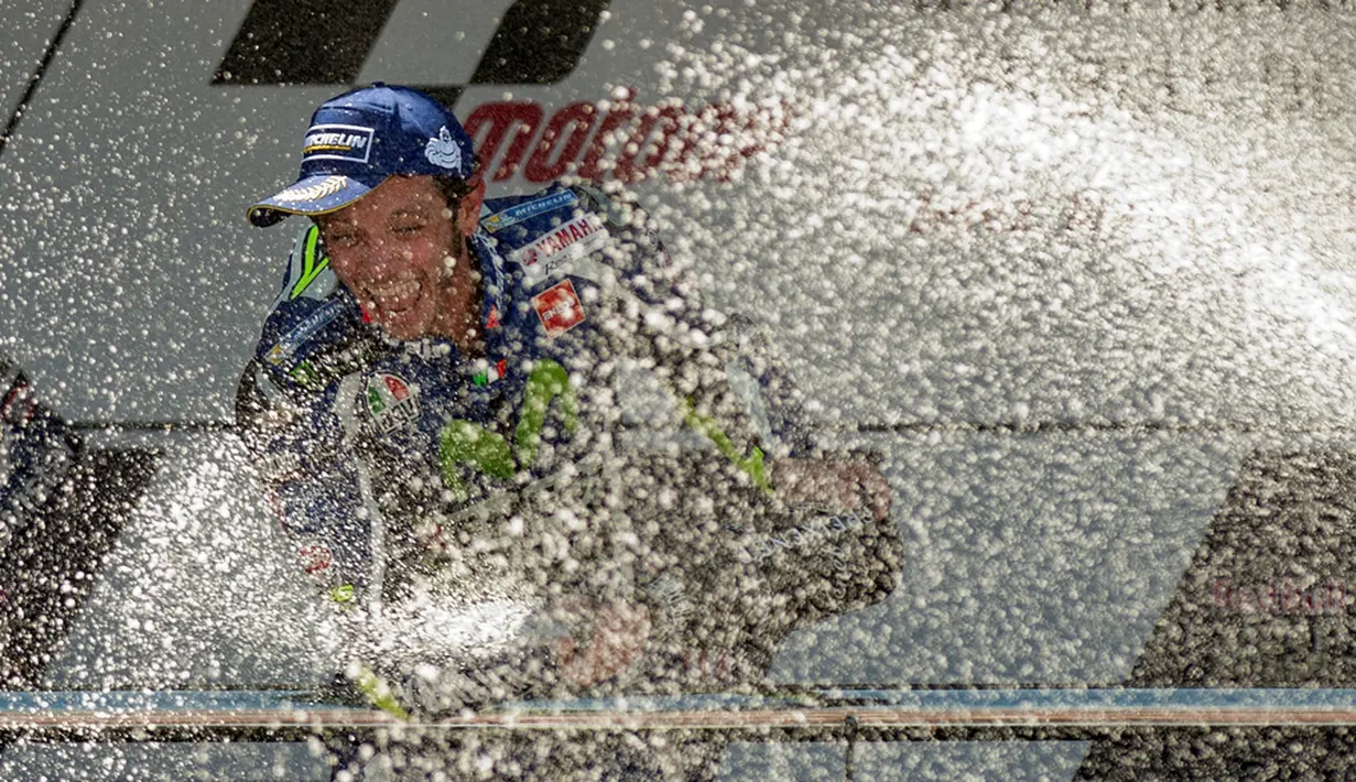 Juara MotoGP Jerez, Valentino Rossi, menyemprotkan sampanye di podium juara Sirkuit Jerez, Spanyol, Minggu (24/4/2016). (AFP/Jorge Guerrero)