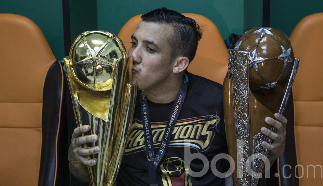 Gelandang Arema FC, Felipe Bertoldo, mencium piala saat merayakan keberhasilan meraih Piala Presiden 2017 di ruang ganti pemain. (Bola.com/Vitalis Yogi Trisna)