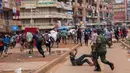 Seorang aparat kepolisian saat membubarkan orang-orang yang masih berkeliaran di Kampala, Uganda (26/3/2020). Pemerintah setempat juga menutup seluruh pintu perbatasan, kecuali untuk barang terbatas dan penerbangan darurat resmi sebagai upaya menekan penyebaran Covid-19. (AFP/Badru Katumba)
