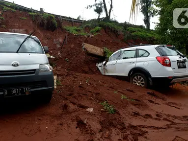 Dua mobil tertimpa longsoran dinding ruas jalan Tol JORR Cikunir, Bekasi, Jawa Barat, Kamis (2/1/2020). Hujan deras pada malam Tahun Baru 2020 membuat sejumlah titik jalan tol rawan longsor dan banjir. (merdeka.com/Imam Buhori)